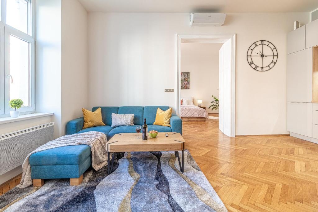 a living room with a blue couch and a table at Stylish luxury flat in Old Town in Staré Mesto