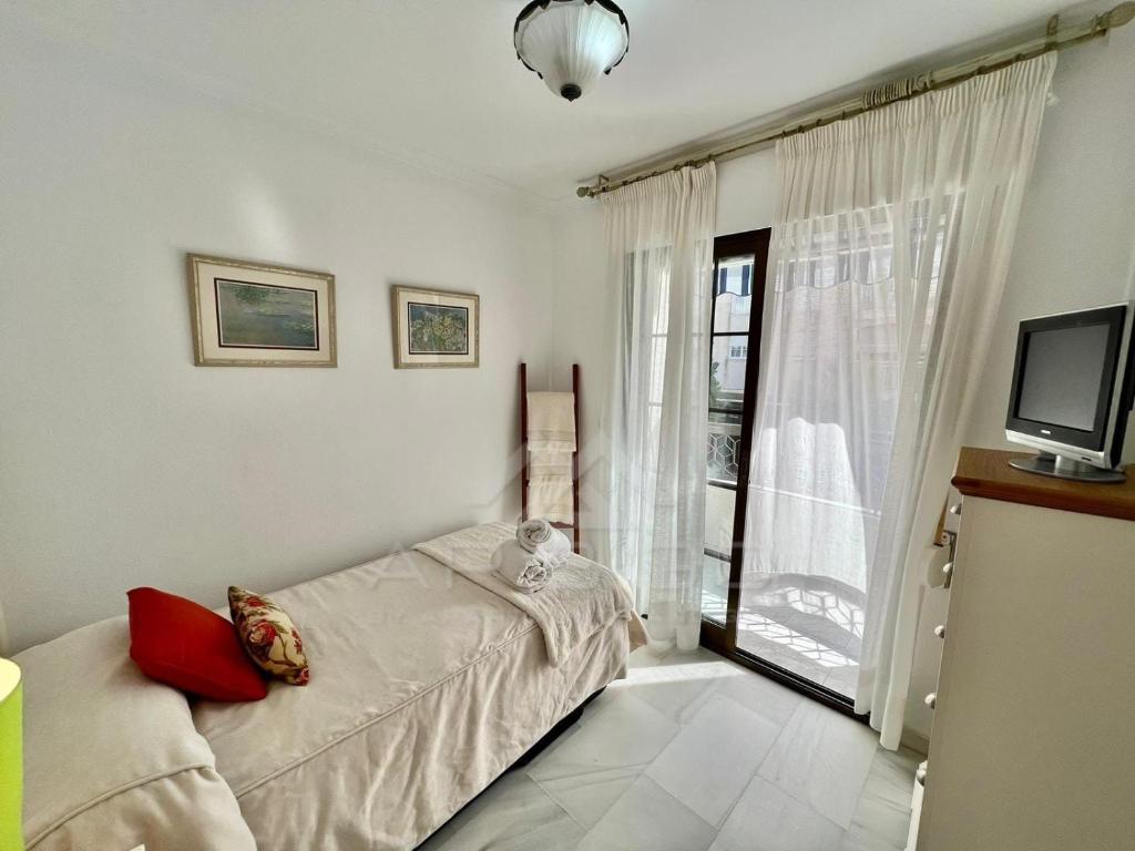 sypialnia z łóżkiem, telewizorem i oknem w obiekcie Precioso apartamento con vistas en la Herradura w mieście La Herradura