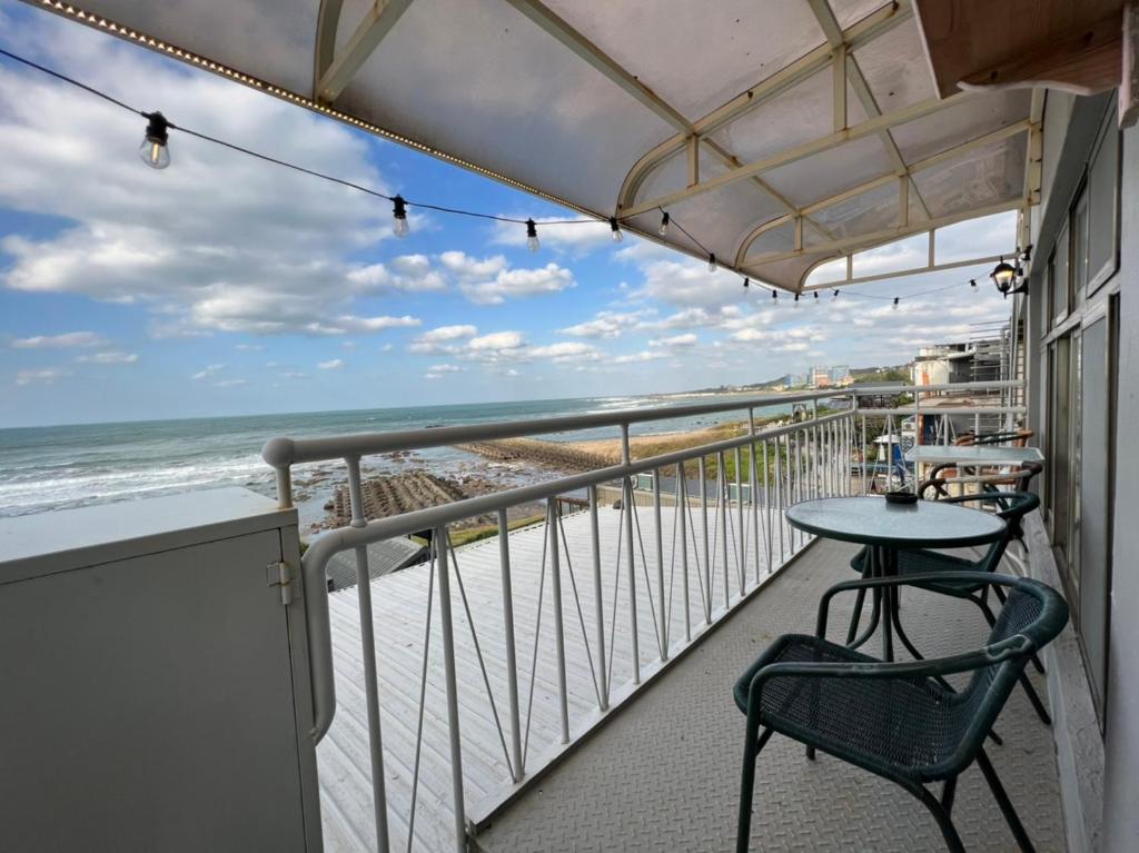 三芝區的住宿－旅途中海邊民宿，一个带桌椅和海滩的阳台