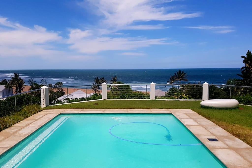a swimming pool with a view of the ocean at Magnificent beach house with stunning ocean views! in Zinkwazi Beach
