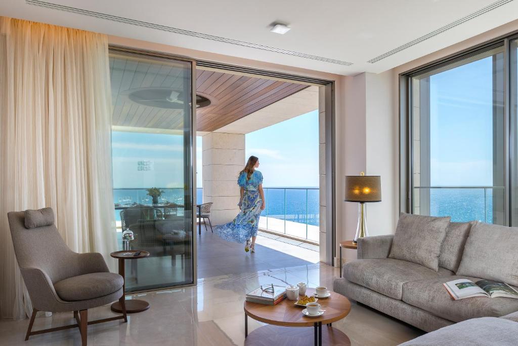 a woman is walking through a living room at Four Seasons Hotel in Limassol