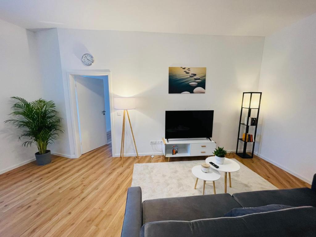uma sala de estar com um sofá e uma televisão de ecrã plano em schönes Apartment - Netflix-Nespresso em Duisburg