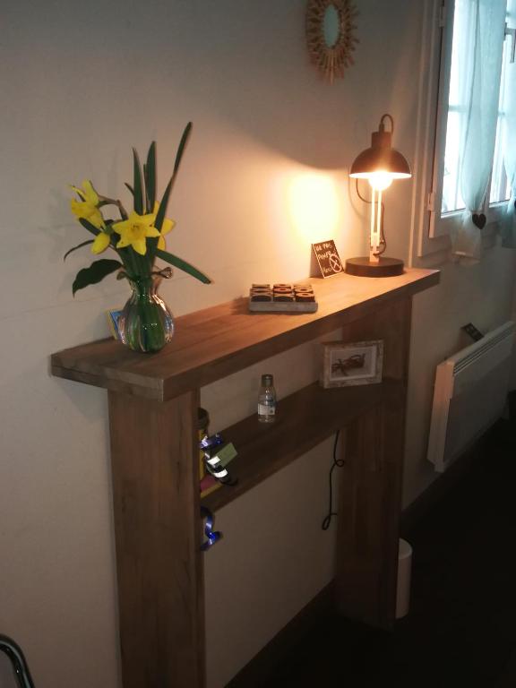 a desk in a room with a vase of flowers on it at Study du pêcheur in Trouville-sur-Mer