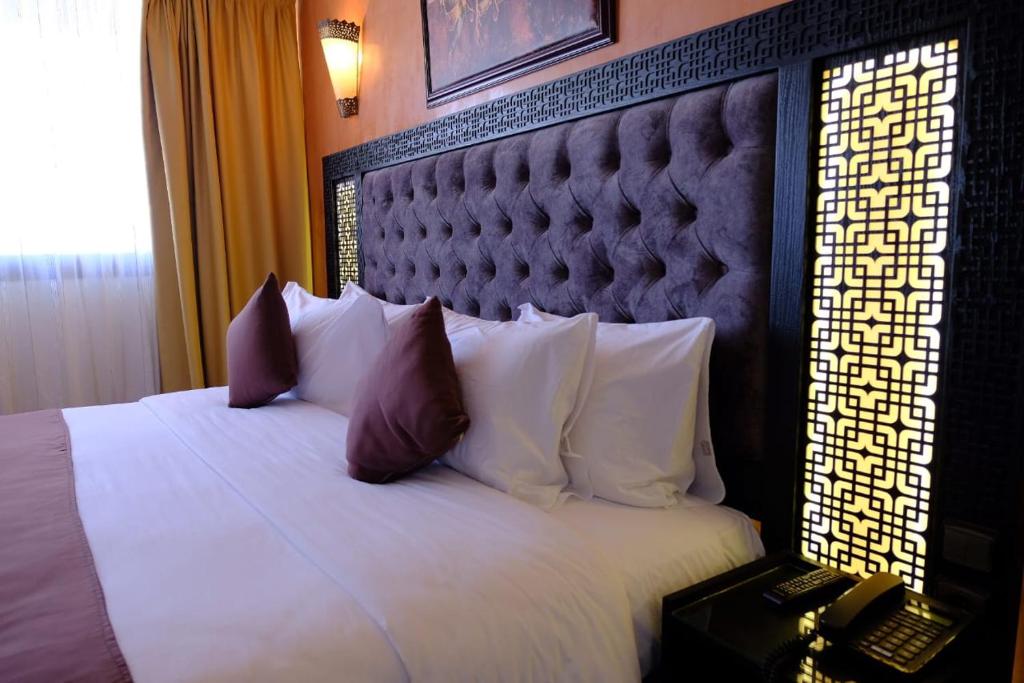 a bedroom with a large bed with white pillows at Washington Hotel in Casablanca