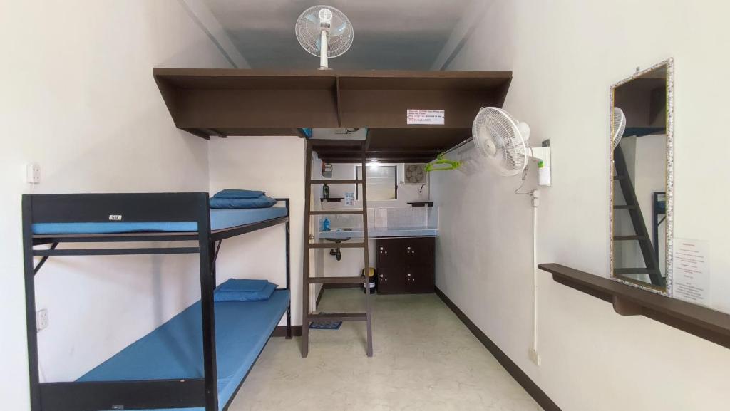 a room with two bunk beds and a fan at Ezekiel Transient House in Coron