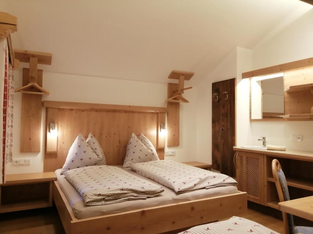 een slaapkamer met een bed, een tafel en een spiegel bij Hintergugg in Mittersill