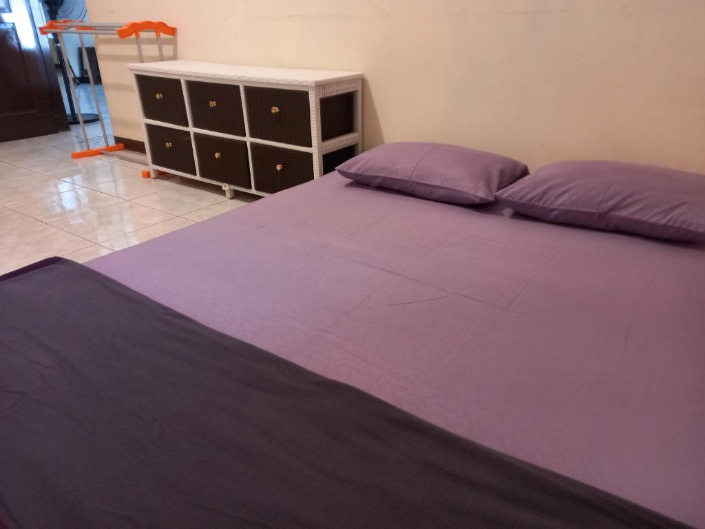 een slaapkamer met een paars bed en een dressoir bij COZY TO STAY TEBET (PENGINAPAN MURAH,TP GA MURAHAN) in Jakarta