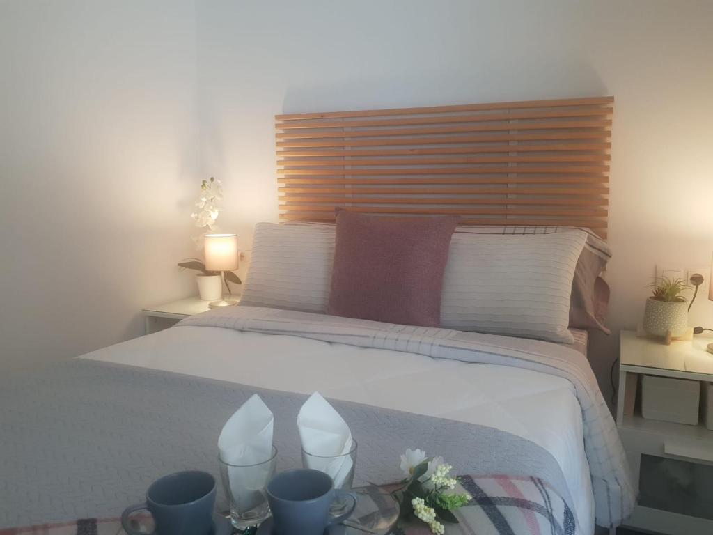 une chambre avec un lit blanc avec une tête de lit en bois dans l'établissement Apartment the Best Weather, à Torremolinos