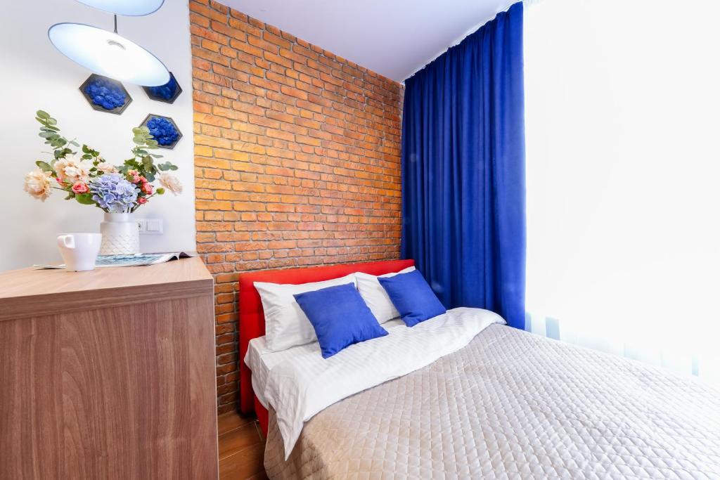 a bedroom with a bed and a brick wall at MYFREEDOM Апартаменти метро Сирець in Kyiv