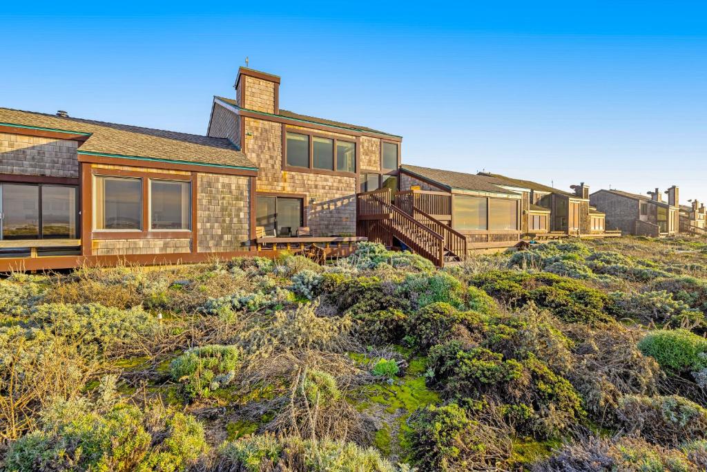 uma casa no topo de uma colina com arbustos em Monterey Dune Dream em Moss Landing