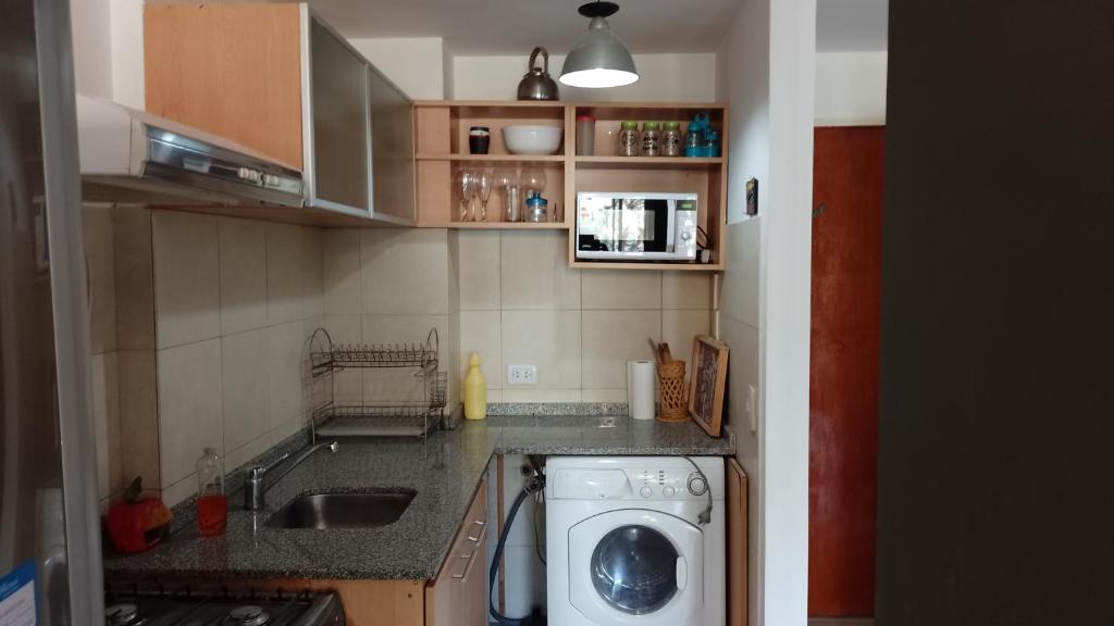 una pequeña cocina con lavadora. en Cañitas en Buenos Aires