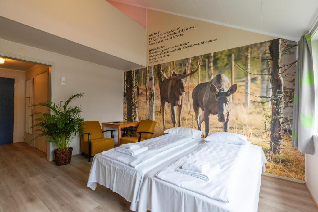 a bedroom with a bed with a picture of a deer on the wall at Namsskogan Familiepark & Hotell in Trones