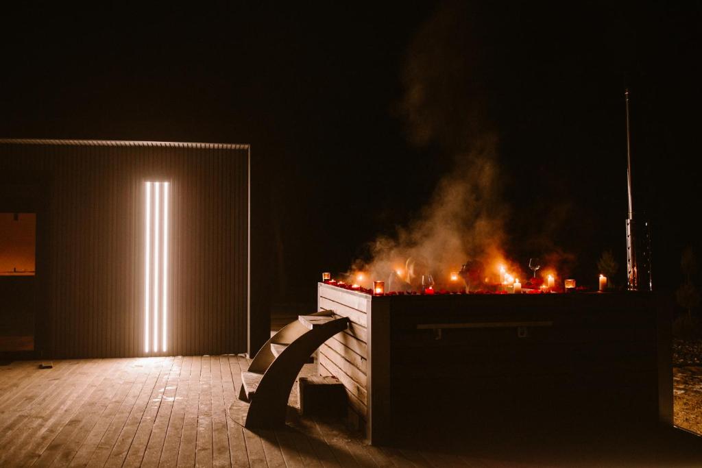a fire pit with a lit up door at night at Mały domek z balią kąpielową in Długosiodło