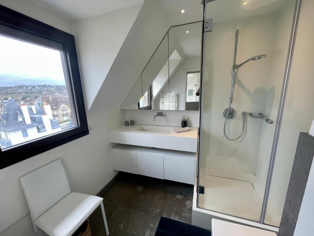 a bathroom with a shower and a sink at Deauville Harmonie - Tout à pied, Balcon &amp; Modernité in Deauville