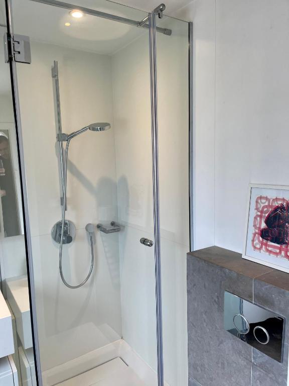 a shower with a glass door in a bathroom at Deauville Harmonie - Tout à pied, Balcon &amp; Modernité in Deauville