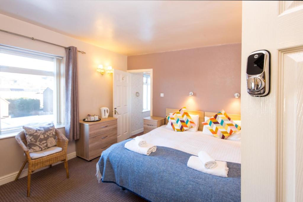 um quarto com uma cama grande e uma janela em Dalesgate Hotel - Self Check In em Keighley