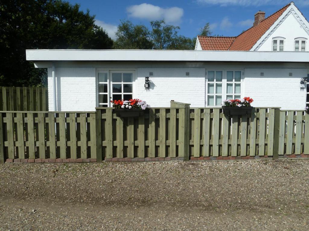 una valla de madera frente a una casa blanca en Havrevang, en Billund