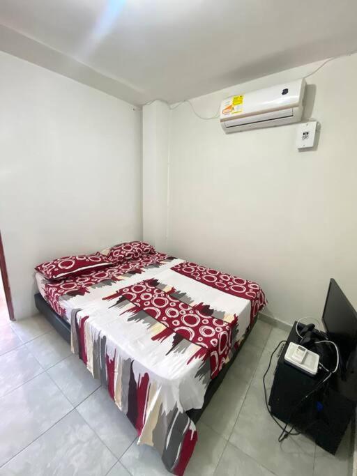 1 dormitorio con 1 cama con manta roja y blanca en 2023 Apartamento Amoblado Múltiple Nogales, en Santa Marta