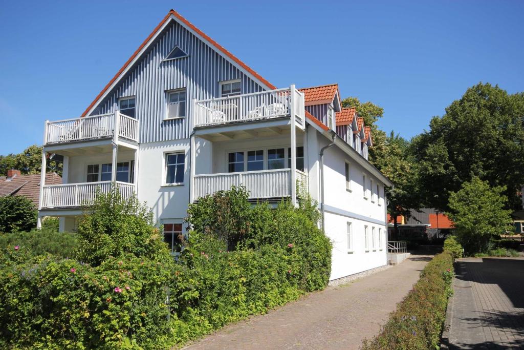 Una casa blanca con balcones en un lateral. en Haus zum Strand 2 4, en Wustrow