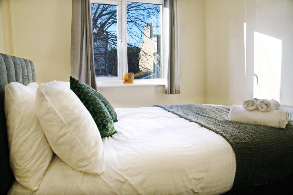 a bedroom with a white bed with a window at Guest Homes - Clacton Coastal Hideaway in Clacton-on-Sea