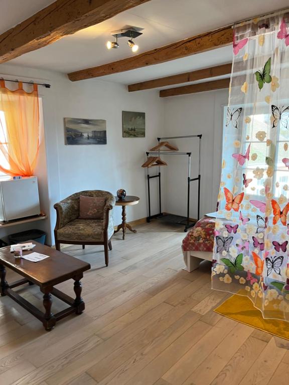 un soggiorno con divano e tavolo di Chambres papillon a La Neuveville