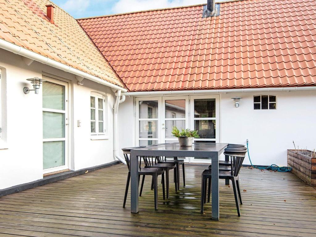 una terraza de madera con mesa y sillas en una casa en Holiday home Allingåbro XXIV, en Allingåbro