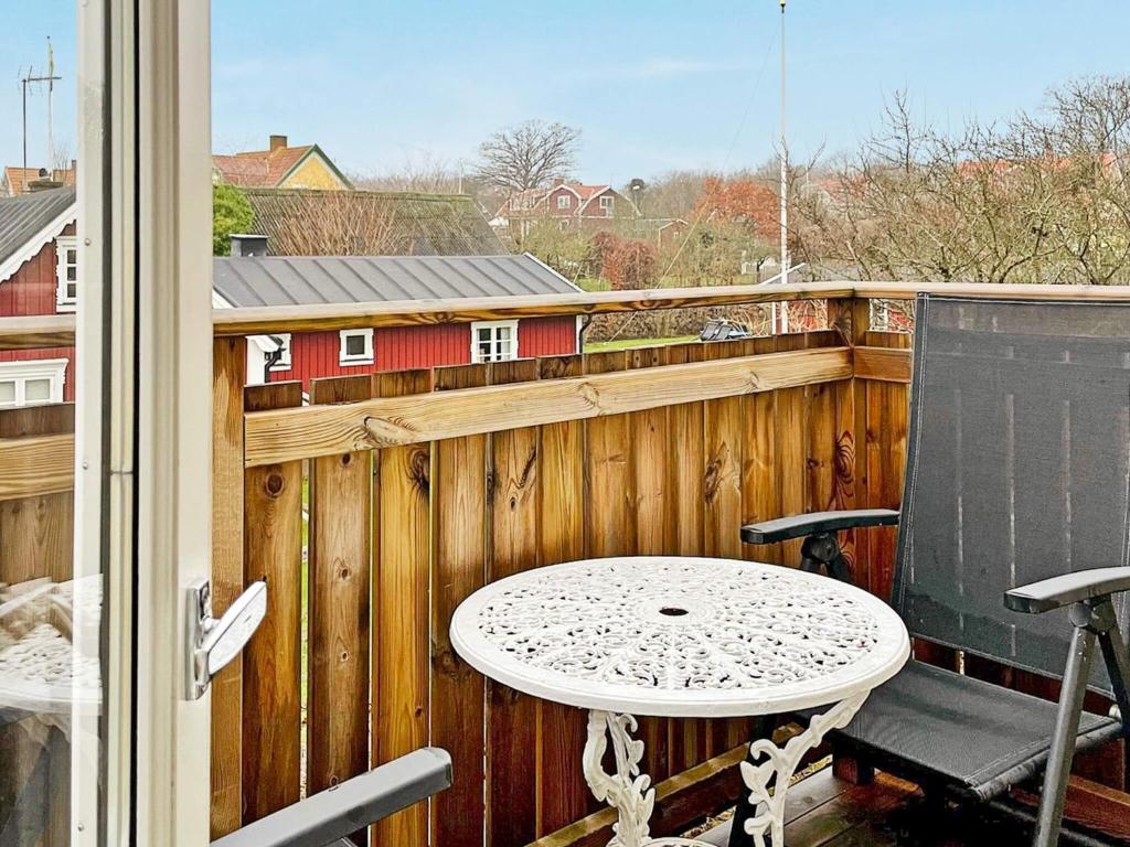 una mesa y una silla en un balcón con una valla de madera en Holiday home SÖLVESBORG XVI, en Sölvesborg