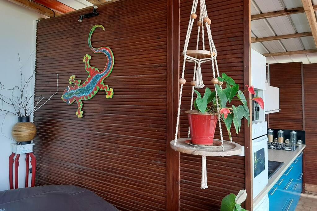 a room with a wooden wall with a lizard on it at Maison MANZÈL à St Esprit - 20 min des plages in Grande Savane