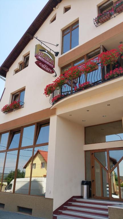a white building with windows and flowers on the balconies at Pensiunea Acasa in Sibiu