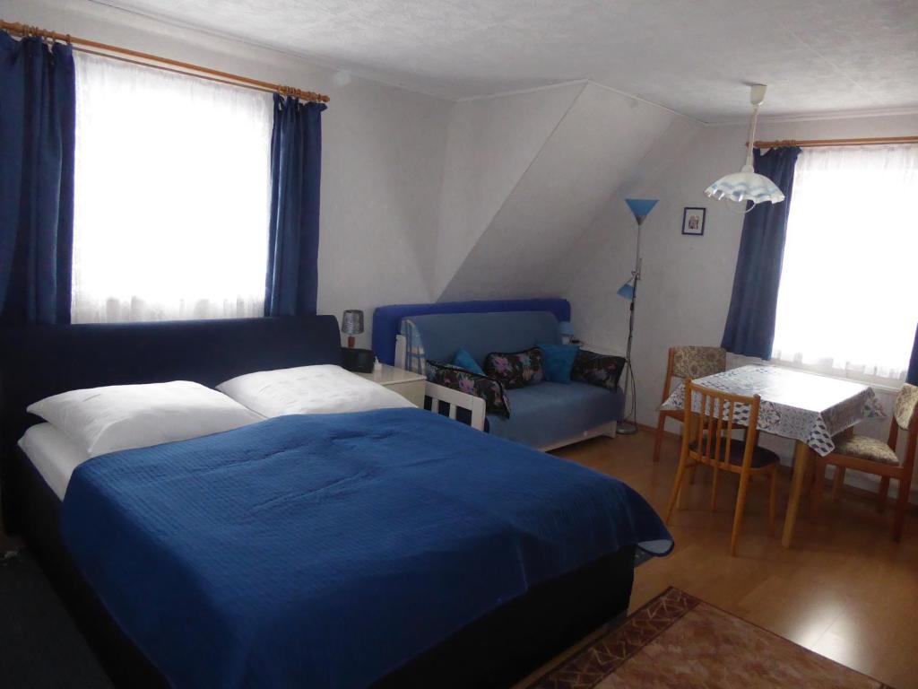 1 dormitorio con 1 cama azul y 1 sofá en Apartment Rumrich, en Kurort Altenberg