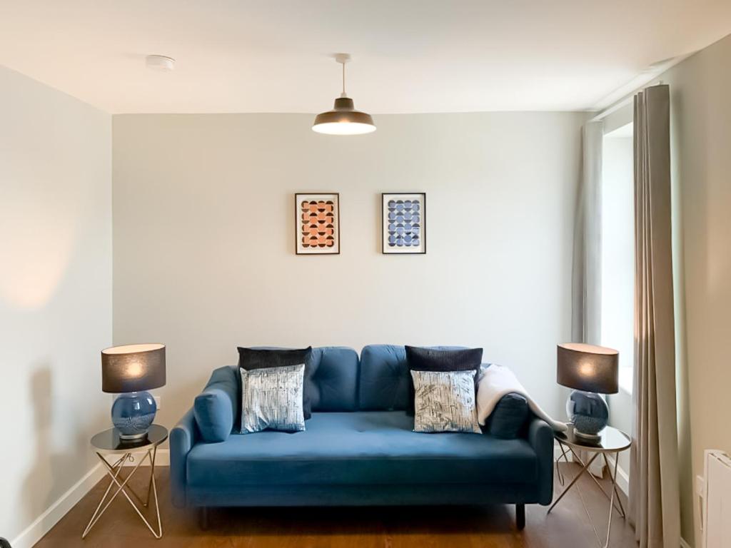 Sofá azul en la sala de estar con 2 lámparas en Nap Bristol East en Bristol