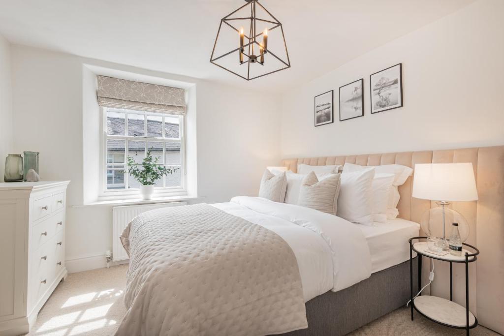 - une chambre blanche avec un grand lit et une fenêtre dans l'établissement Weavers Cottage, Sleeps 4, town centre, à Kirkby Lonsdale