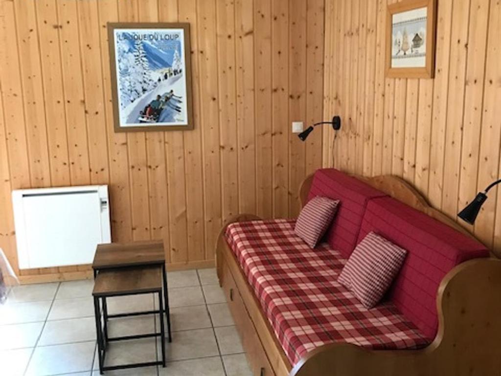 ein Wohnzimmer mit einem roten Sofa und einem Tisch in der Unterkunft Chalet La Joue du Loup, 3 pièces, 7 personnes - FR-1-504-592 in Le Dévoluy