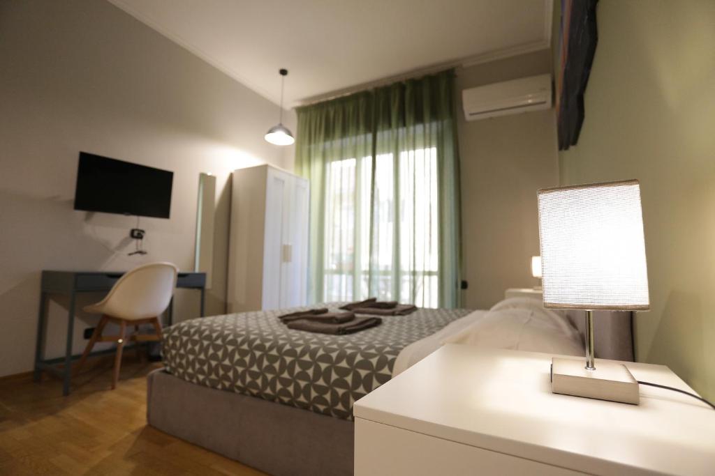 a bedroom with a bed and a desk with a lamp at Vomero Maison in Naples