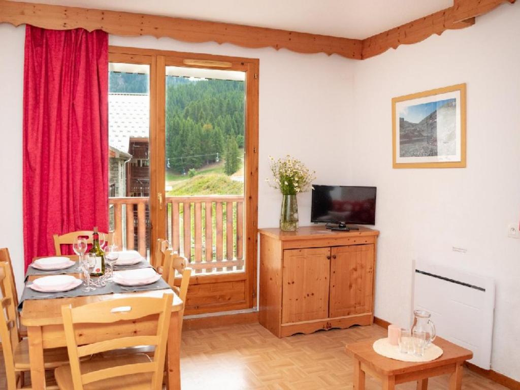 une salle à manger avec une table et une télévision dans l'établissement Bel Appartement 3 Pièces avec Balcon, Local Ski et Parking - FR-1-504-613, à Puy-Saint-Vincent