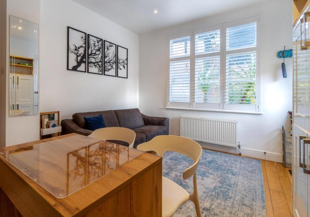 a living room with a glass table and chairs at Talbot Lane Cottage Horsham By My Getaways in Horsham