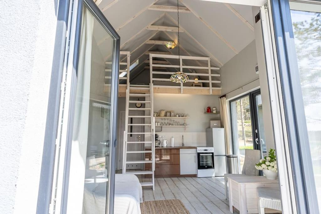 a view of a kitchen from the porch of a tiny house at Wrzosowe Wzgórze - Domek wiejski in Kłaczno