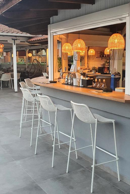 a bar with white bar stools in a restaurant at Palladium Hotel in Kriopigi