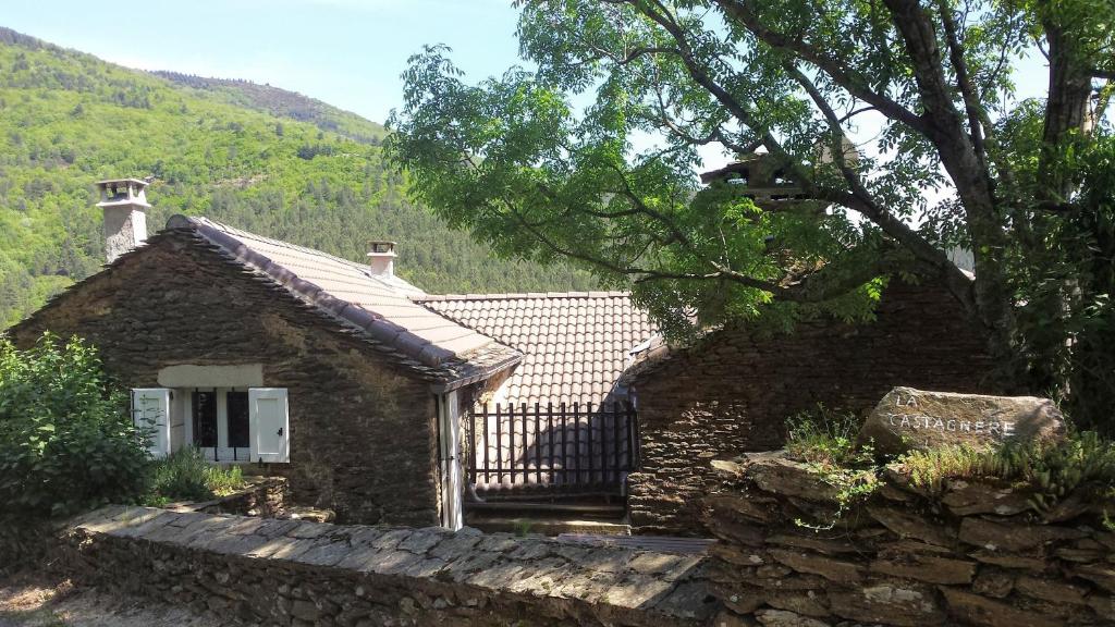 une petite maison en pierre avec un mur en pierre dans l'établissement Gite Castagnere 4* en Cévennes, à Aujac