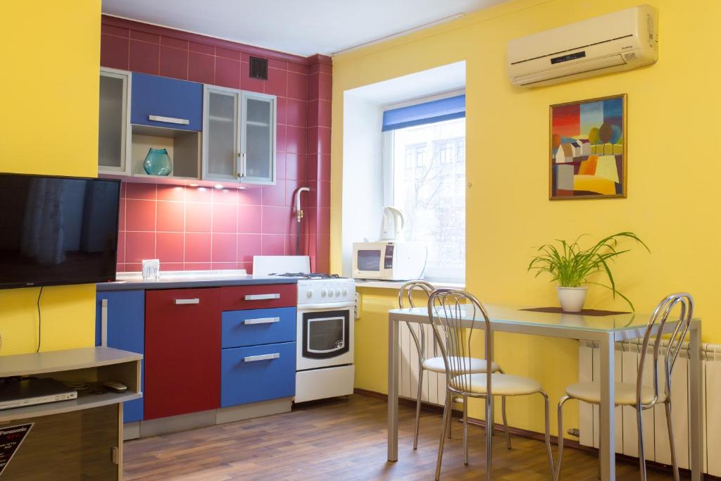 a kitchen with colorful cabinets and a table and chairs at Botanical garden area in Kharkiv