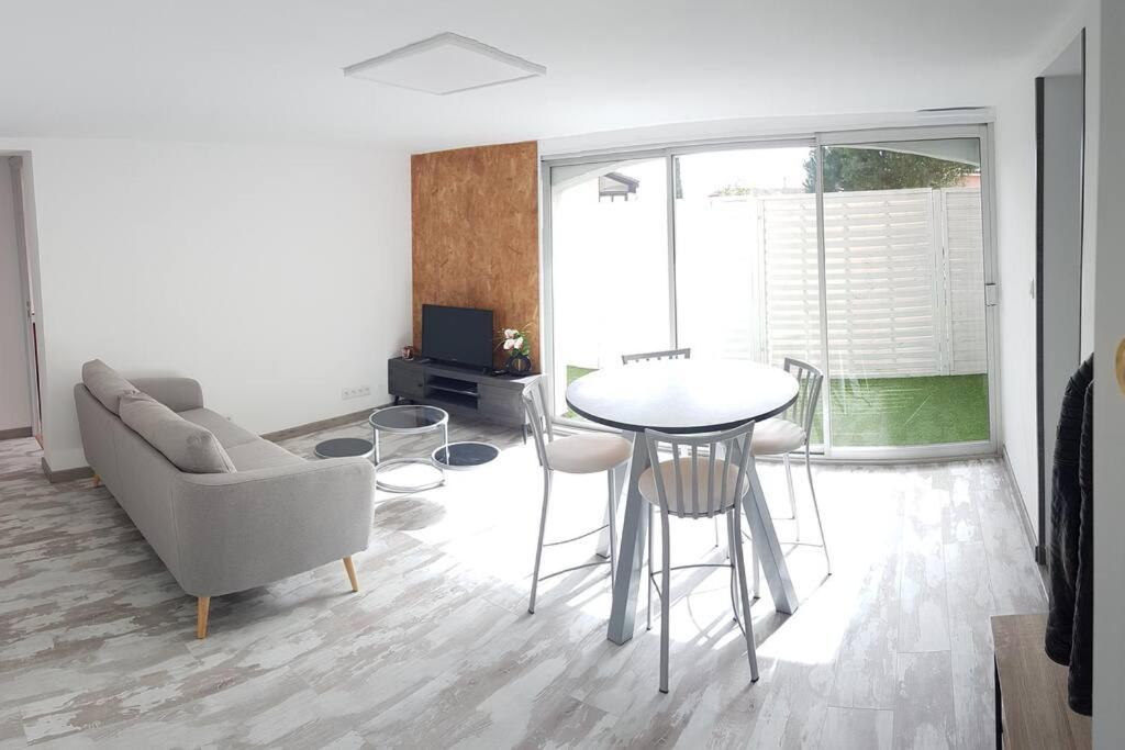 - un salon avec un canapé, une table et des chaises dans l'établissement Joli appartement 2 chambres à Martigues, à Martigues