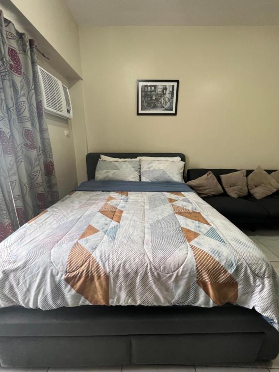een slaapkamer met een bed met een quilt bij SunVida Tower in Cebu City