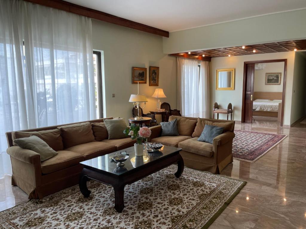 een woonkamer met een bank en een salontafel bij Athens Neos Kosmos penthouse, sea and city view in Athene