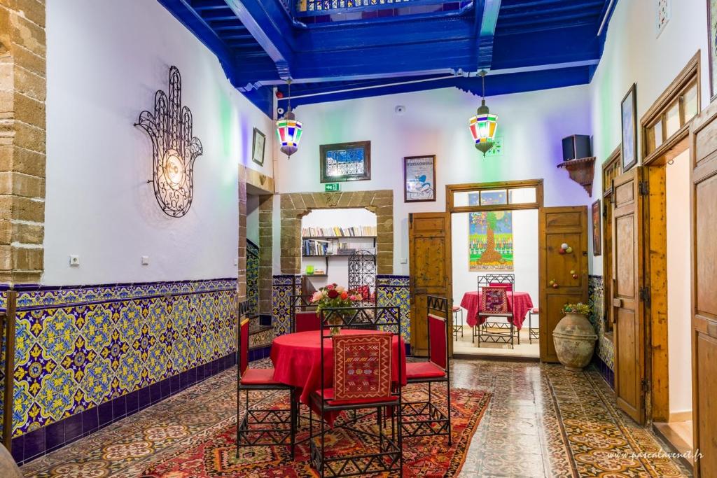 una sala da pranzo con tavolo e sedie rossi di Dar Halima a Essaouira