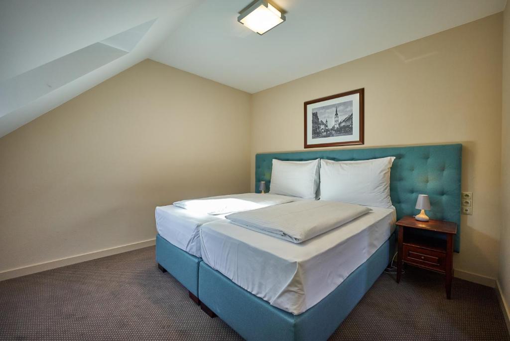 Un pat sau paturi într-o cameră la Pension & Restaurant PATRIOT Trnava
