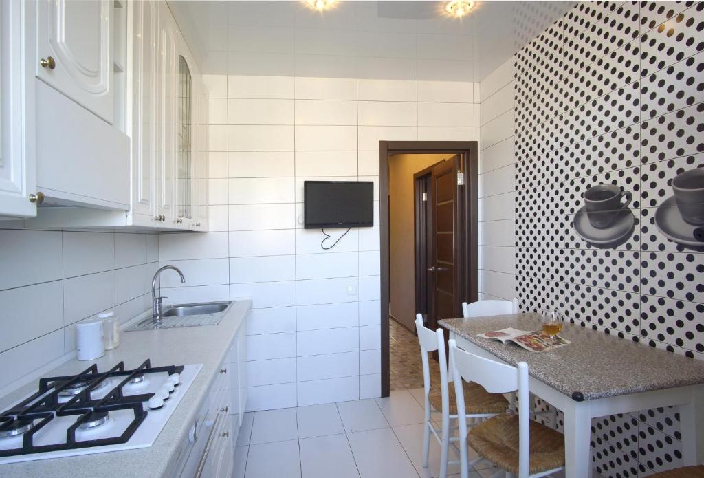 Una cocina con fregadero y una mesa con sillas. en Silent center Apartment, en Járkov