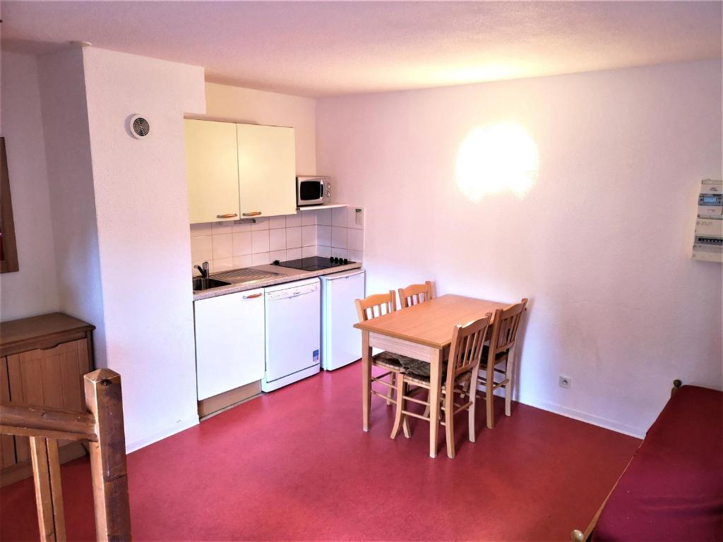 a small kitchen with a wooden table and chairs at Appartement La Joue du Loup, 2 pièces, 4 personnes - FR-1-504-573 in Le Dévoluy