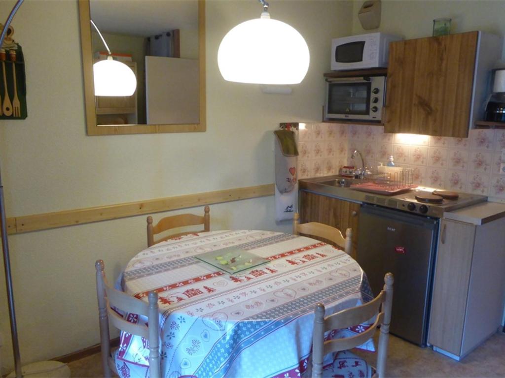 une petite cuisine avec une table, un évier et une table dans l'établissement Studio au centre du village de Samoëns, avec balcon, proche ski-bus, animaux acceptés - FR-1-629-56, à Samoëns
