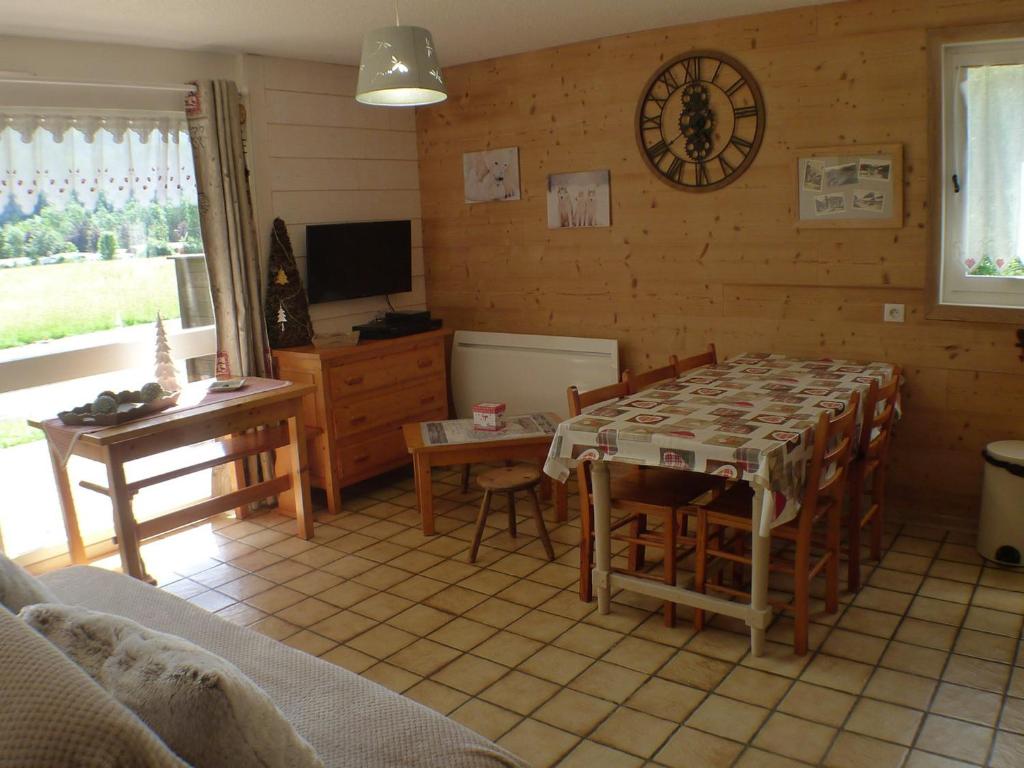 een woonkamer met een tafel en stoelen en een televisie bij Appartement Samoëns, 2 pièces, 6 personnes - FR-1-629-16 in Samoëns