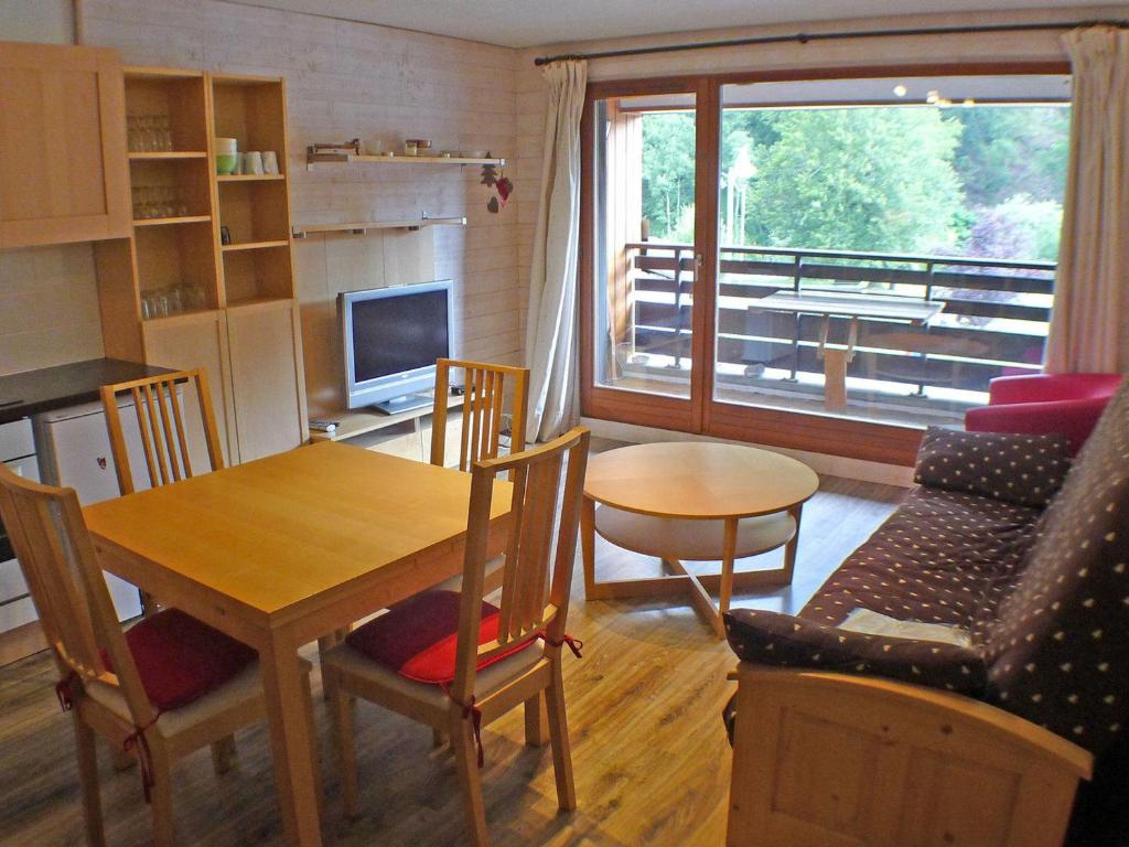 une cuisine et un salon avec une table et des chaises dans l'établissement Studio confortable face aux télécabines, proche loisirs avec parking et animaux admis à Samoëns - FR-1-629-54, à Samoëns